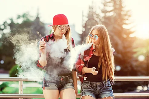 iki genc kiz puff bar e-sigara kullanıyor